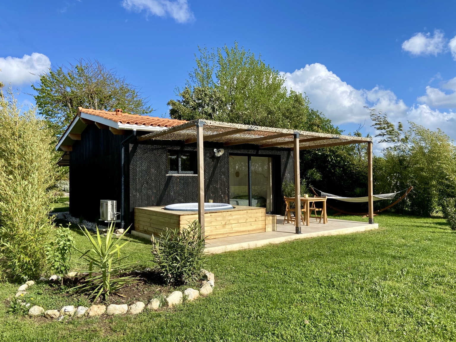 Extérieur de La Cabane Noire et sa terrasse face à la campagne